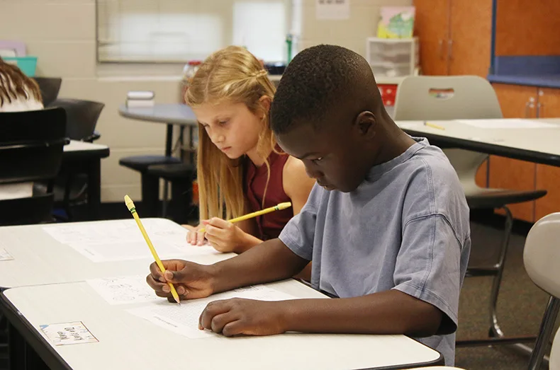Third-grade students work on an assignment at Prairie Creek Elementary School on the first day of school.