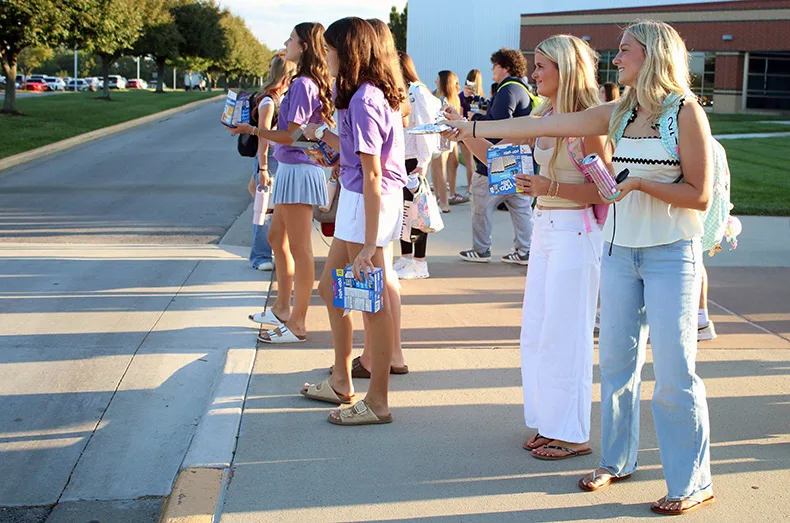 Members of the student council hand out Pop-Tarts to students arriving at Spring hill High School for the first day of school.