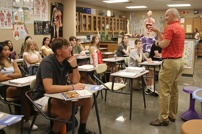 Students listen to their science teacher on the first day of school at Spring Hill High School.