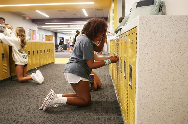 A student opens a locker during passing period at Woodland Spring Middle School.