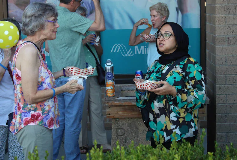 From left, Christy Robertsen of Shawnee and Amber Haq of Overland Park enjoy some free tacos from A & J Molcajete at the Alliance for a Healthy Kansas "One Nation, Overcharged" event at Rosanna Square on Thursday, Aug. 27.
