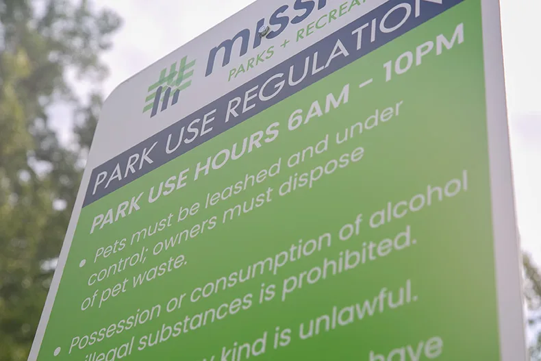 A sign at Broadmoor Park in Mission states that "pets must be leashed and under control" at the park. Similar signs can be found across parks in Johnson County, as cities require some form of leashing of pets. Photo credit Juliana Garcia. 