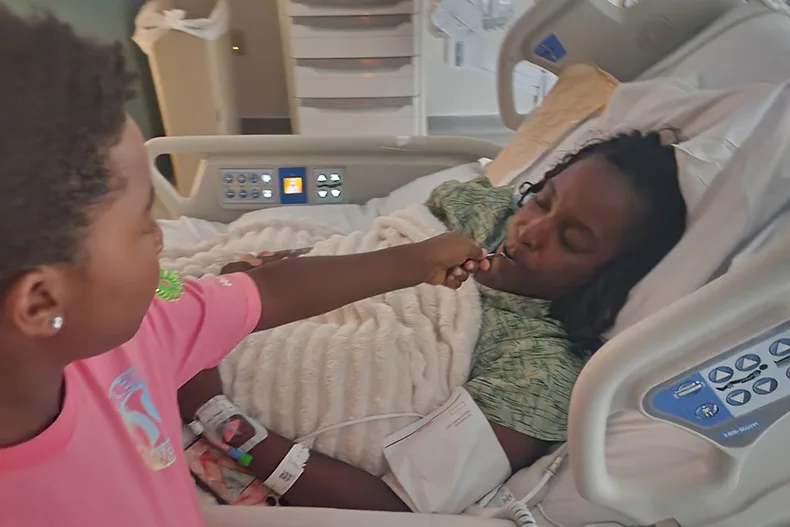 Monique Johnson being fed after her spinal surgery the final week of July. Photo courtesy Alexis Ellis.