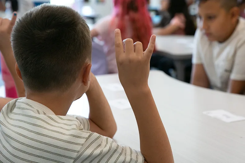 Another third grade boy uses the Pawnee Panthers hand signal for active listening. Photo credit Juliana Garcia.