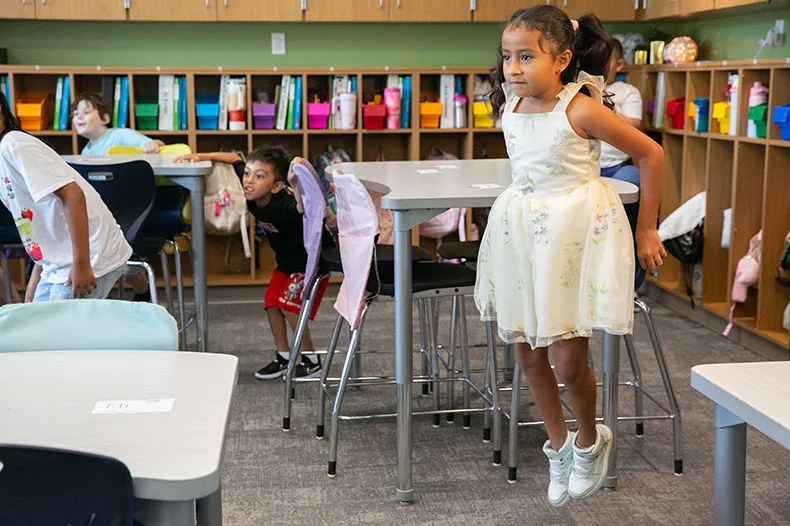 A third grader jumps high during a brain break of the first day of school in 2026. Photo credit Juliana Garcia.