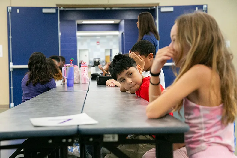 A fourth grade boy at Pawnee Elementary sits through a cafeteria procedure refresher on the first day of school in 2026. Photo credit Juliana Garcia.