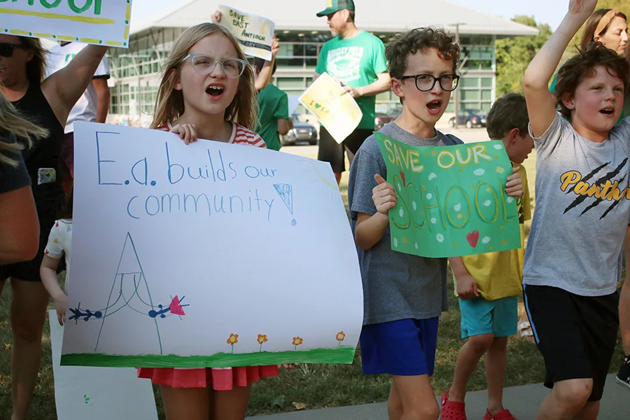 From left, Pippa Coon, 9, Jackson Cooper, 10, and Will Cardin, 9, show their support for East Antioch while protesting its proposed closure at a rally Sept. 1.