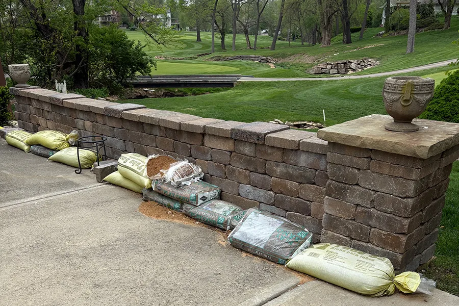 Wenonga Lane resident B.J. Collins keeps sandbags along a wall in her backyard when the grounds flood in the Leawood Country Club behind her property.