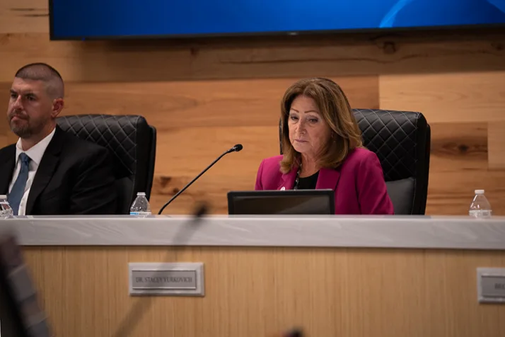 Olathe Board of Education member Stacey Yurkovich looks down Thursday night while fellow board members make comments following the unanimous decision to close five elementary schools and one middle school. Photo credit Margaret Mellott.