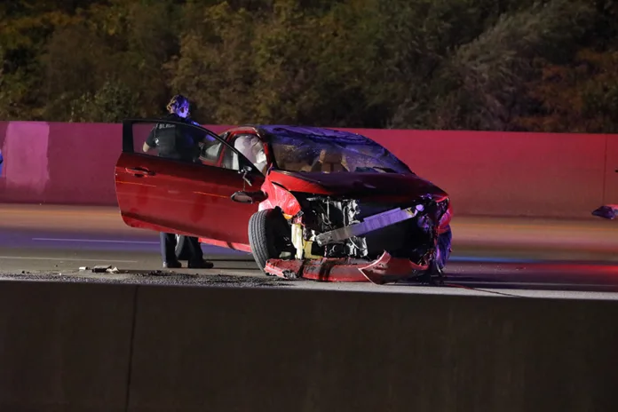 A Lenexa Police officer searches the crashed vehicle after it was put back on its wheels.