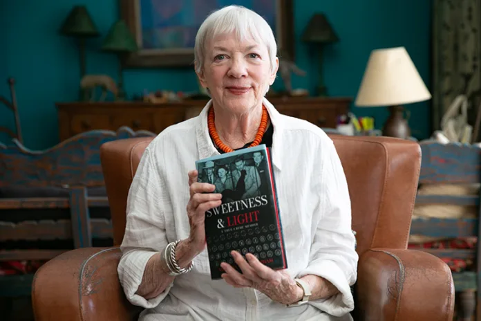 Melinda Worth Popham, in her Overland Park home, holds her second memoir, 