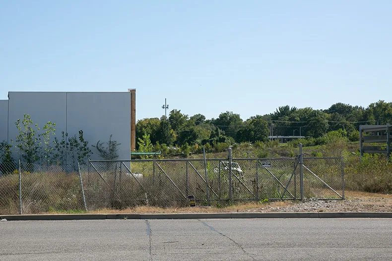 Mission Gateway, featuring the would-be Cinergy building and the parking structure (right). Weeds are overgrown to the point that some are small trees. Photo credit Juliana Garcia.
