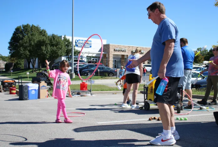From left, Roeland Park resident Estelle Botts, 6, tosses a hula hoop to James Engelhardt of Fairway during Roeland Park's 75th anniversary celebration Oct. 3.