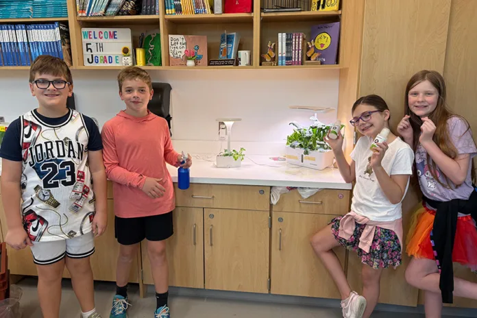Students from April Cremer's fifth grade class last year pose with the plants they grew as part of the Willie and the Salad Bonanza program.
